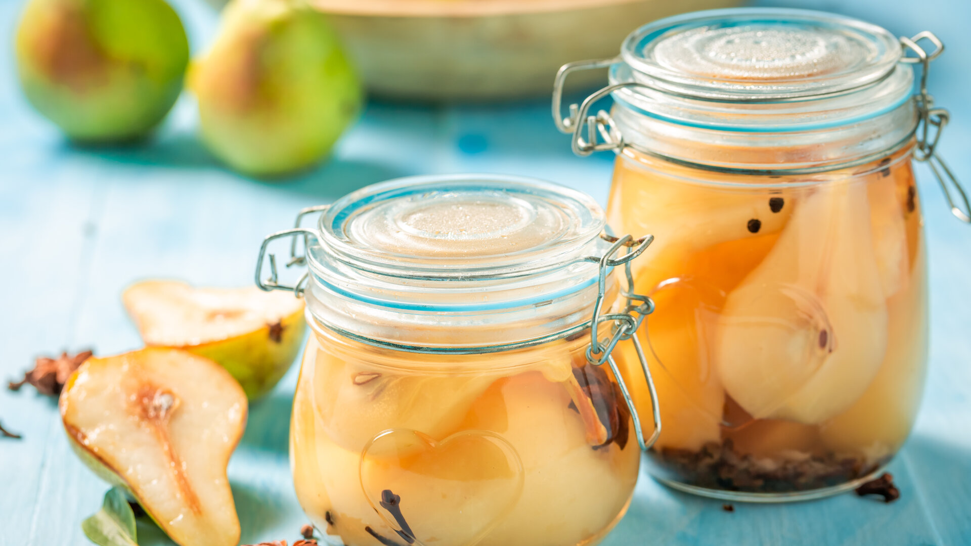 Two swing-top glass jars with rubber seals, filled with preserved pear halves and cloves, stand on a pale blue wooden table. In front of them lie a pear cut in half and star anise, behind them fresh green pears. A visual metaphor for an archive: preserved, closed, and trustworthy only as long as its seal can be checked.
