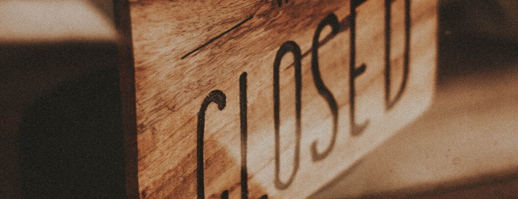 The image shows a wooden sign with the word 