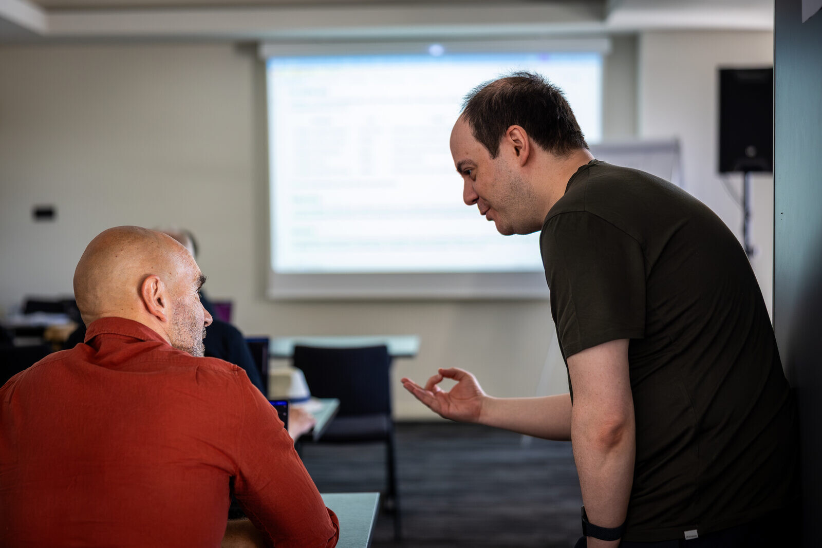 Sebastian Bergmann talking with a participant during a workshop