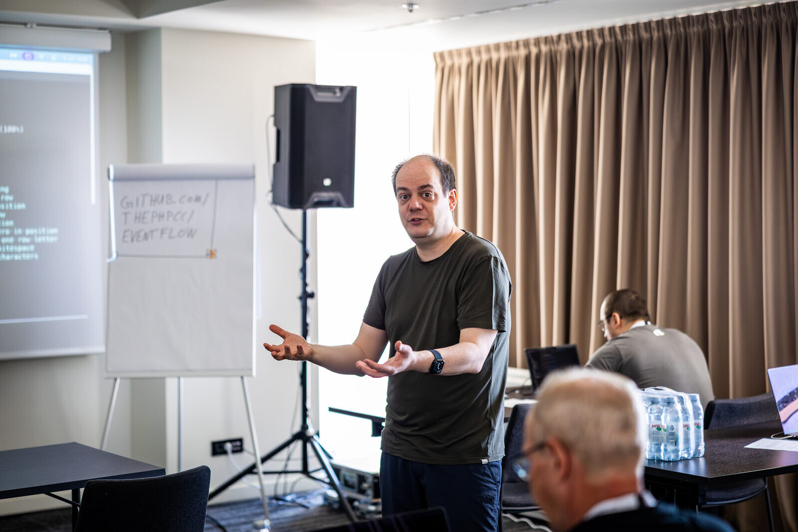 Sebastian Bergmann explaining a concept in front of a flip chart